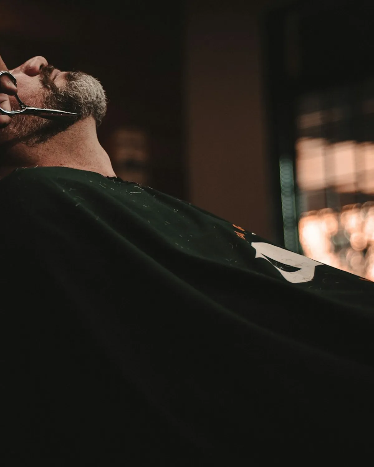 Barbero recortando una barba con tijeras