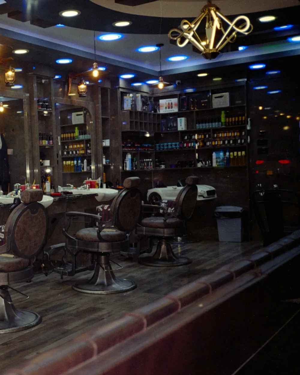 Interior de la barbería con sillas y espejos