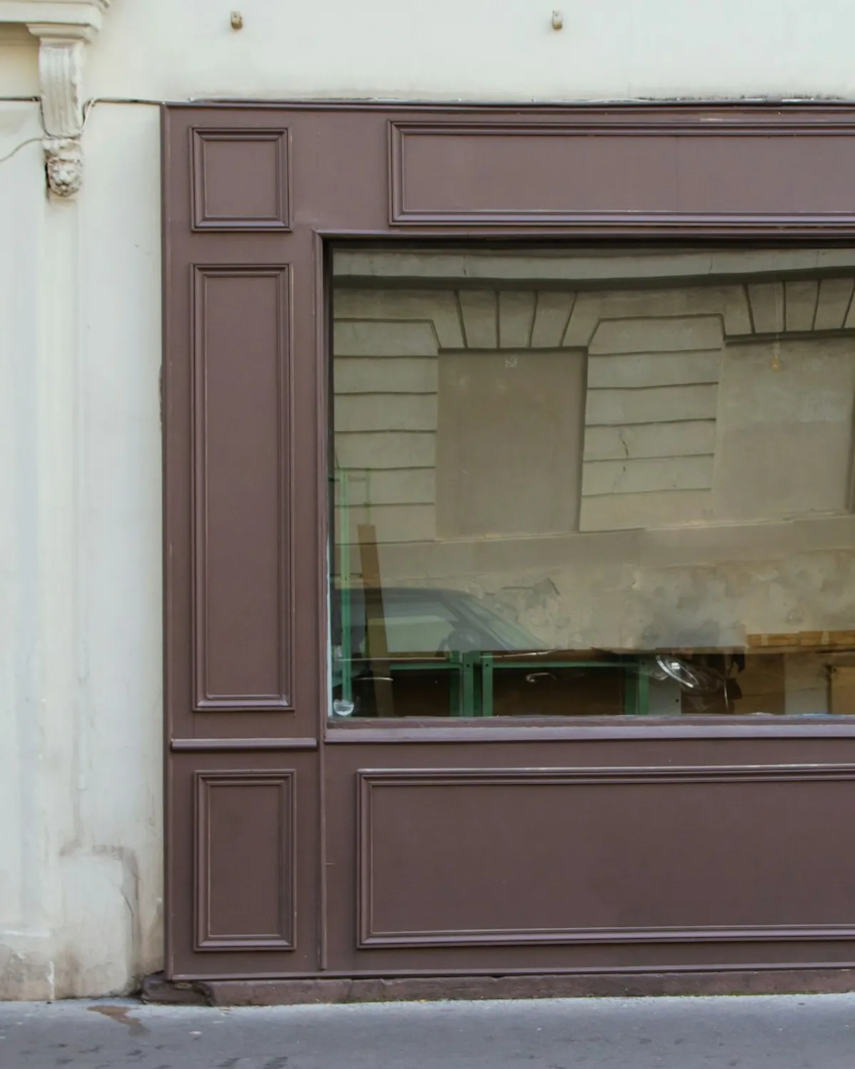 Fachada de una tienda de ropa, ventanal con marco de madera