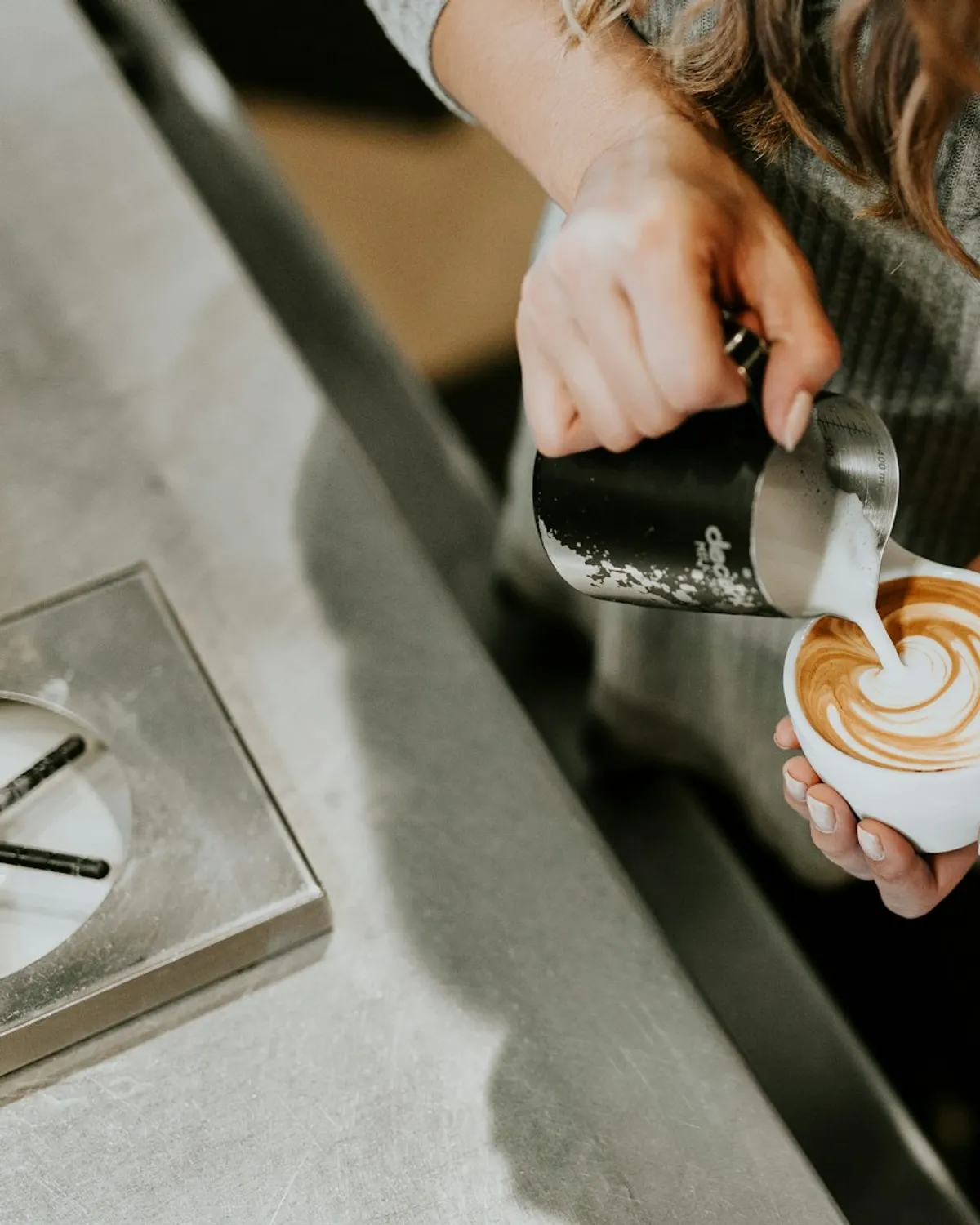 Barista sirviendo un latte con arte de leche