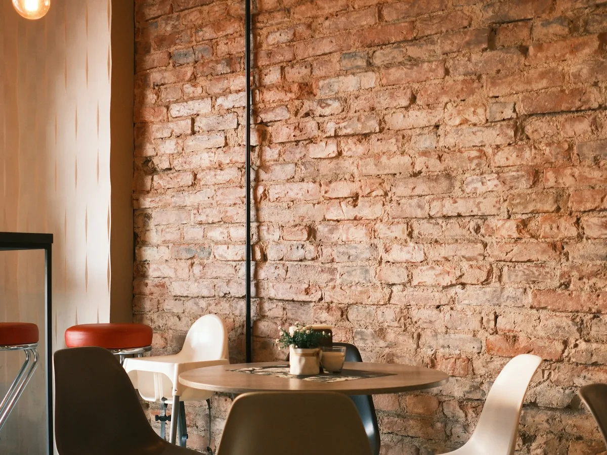 Mesa de madera junto a la pared de ladrillo de la cafetería