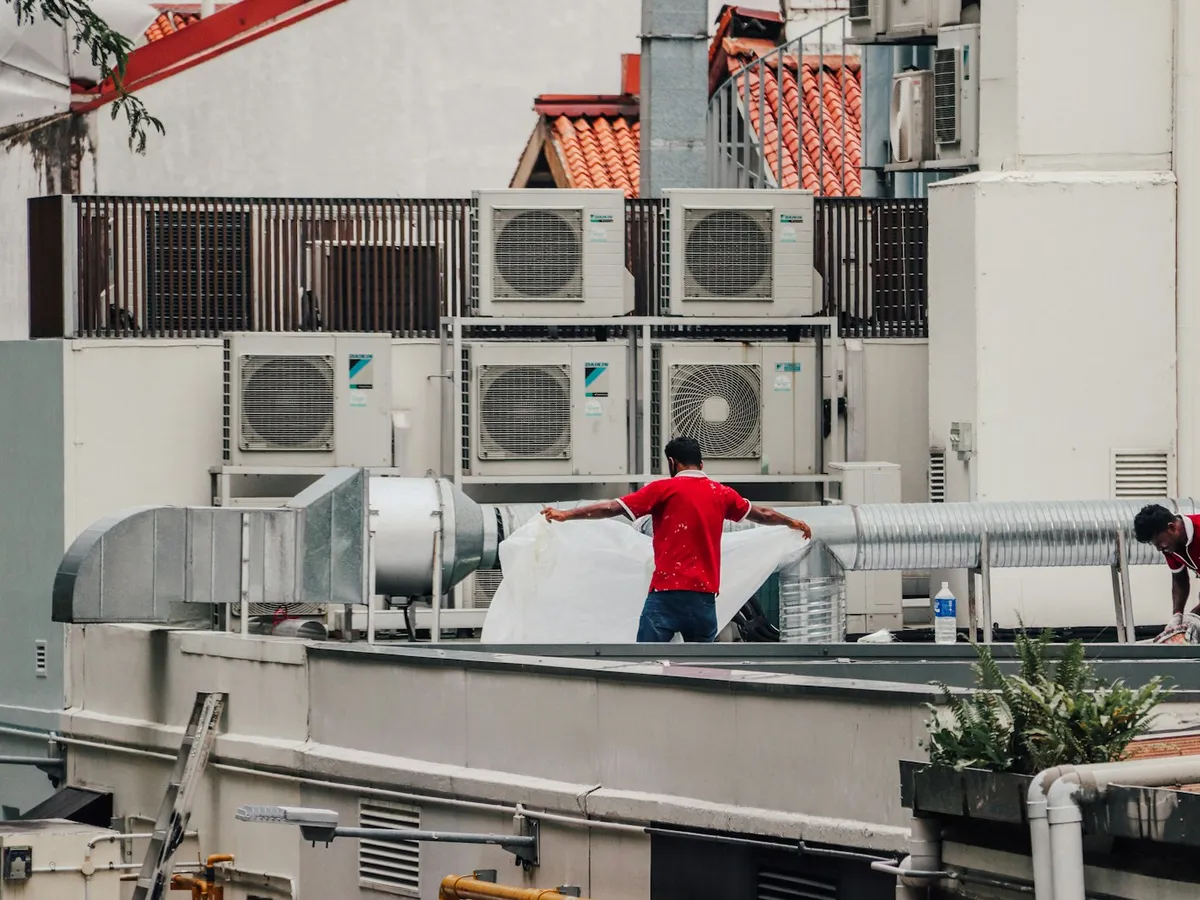 Técnicos trabajando en unidades de aire acondicionado sobre una azotea