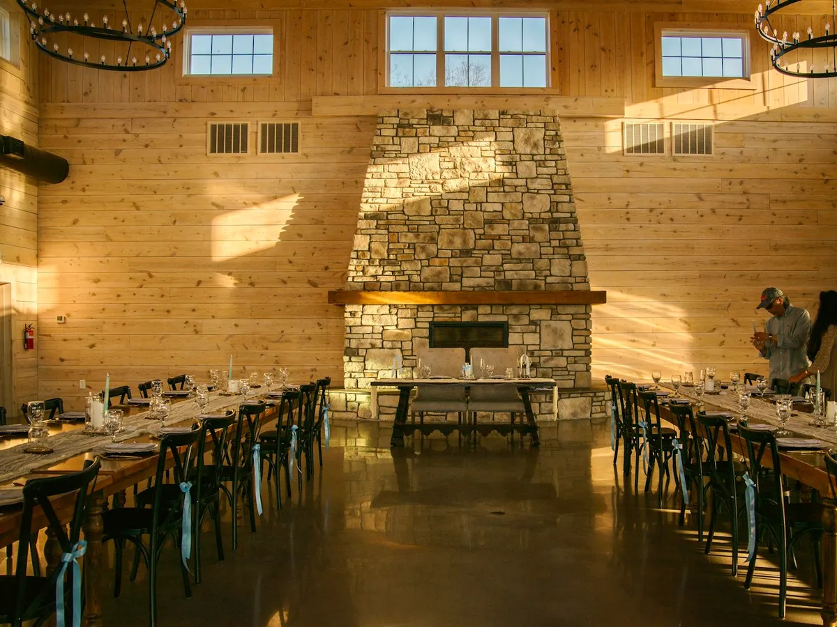 Salón con chimenea de piedra y mesas largas