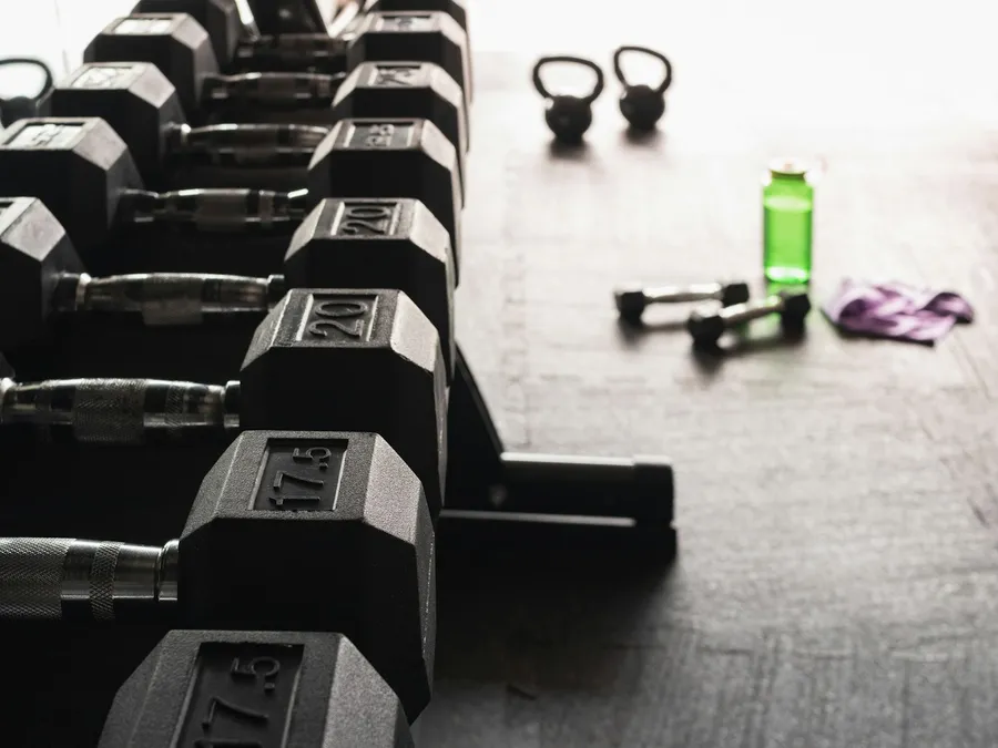 Kettlebells y mancuernas hexagonales en el piso