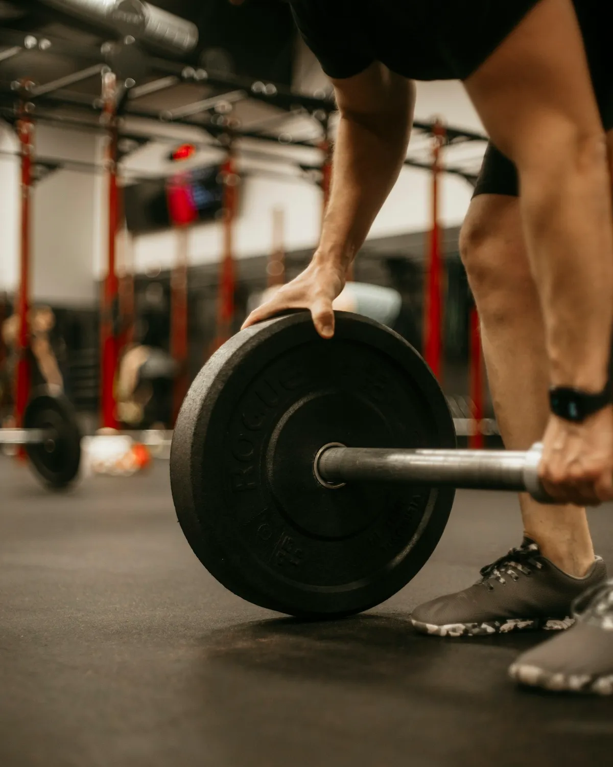 Persona levantando una barra con discos en el gimnasio