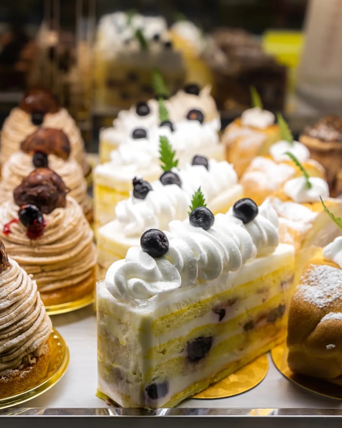 Pasteles individuales con crema y frutos del bosque en vitrina