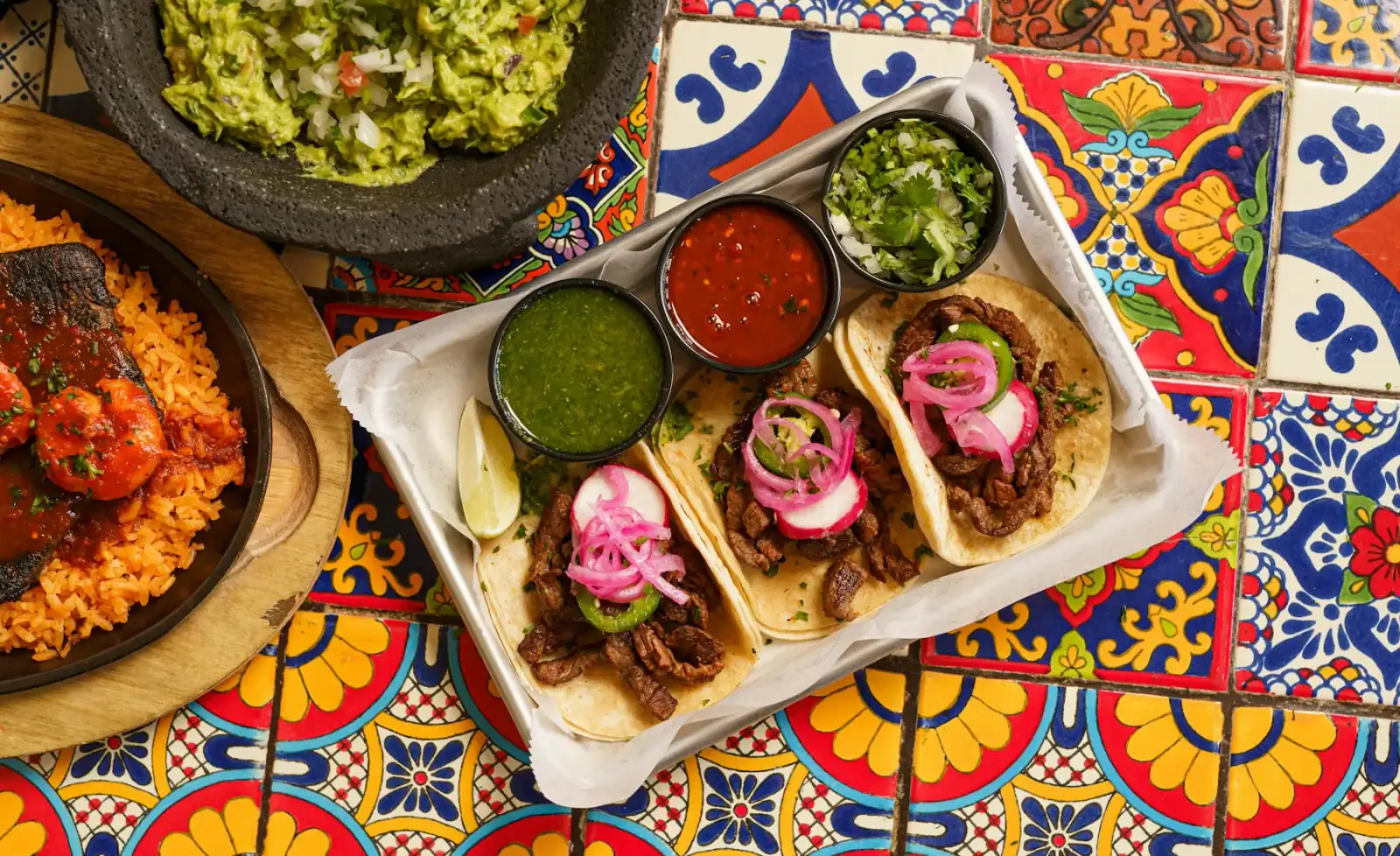 Tacos de trompo con salsas sobre azulejo de talavera