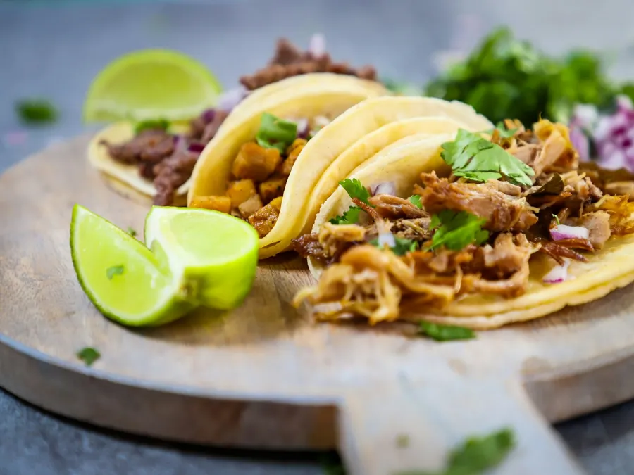 Tacos de trompo recién cortados con piña y cilantro